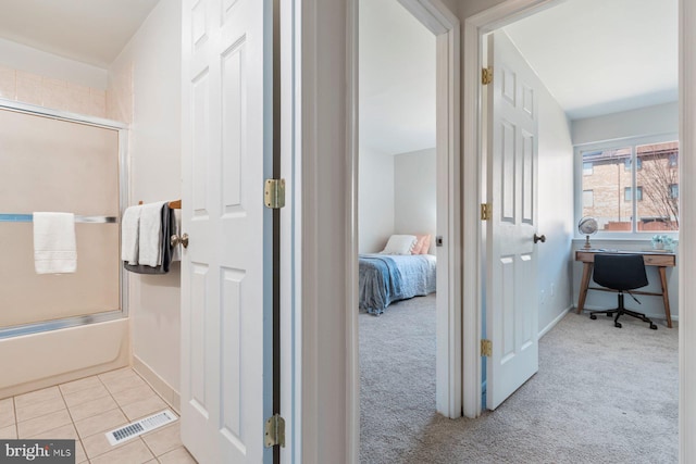 bathroom featuring bath / shower combo with glass door, visible vents, connected bathroom, tile patterned flooring, and baseboards