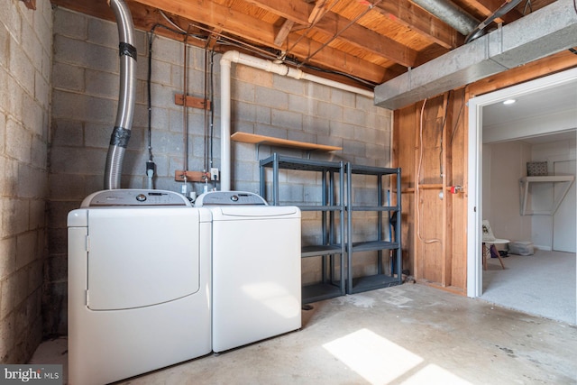 laundry room featuring concrete block wall, laundry area, and washer and dryer