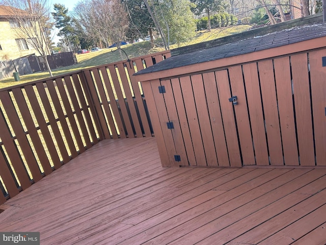 wooden deck with a storage shed and an outdoor structure