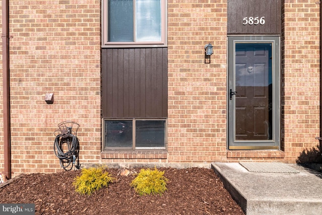 view of exterior entry featuring brick siding