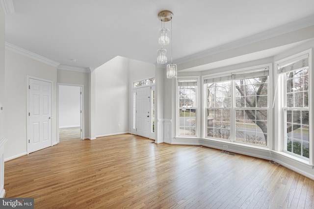 interior space with ornamental molding, light wood finished floors, and baseboards