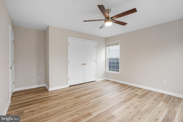 unfurnished bedroom featuring ceiling fan, a closet, light wood-type flooring, and baseboards