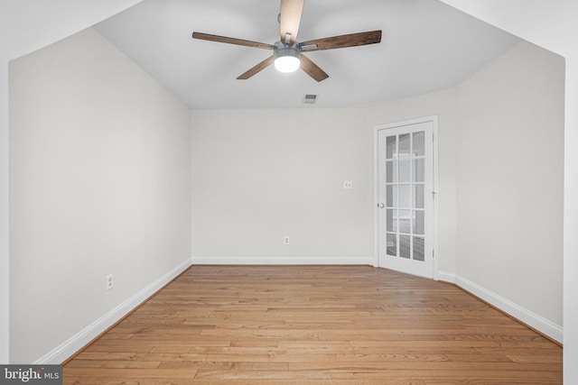 spare room featuring light wood-type flooring, visible vents, ceiling fan, and baseboards