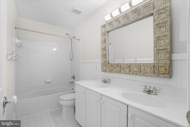 full bath featuring a wainscoted wall, visible vents, a sink, and tile patterned floors