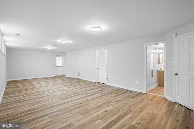 unfurnished room with baseboards and light wood-style floors