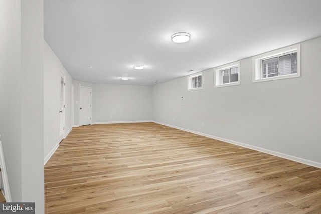 basement featuring light wood-style flooring and baseboards