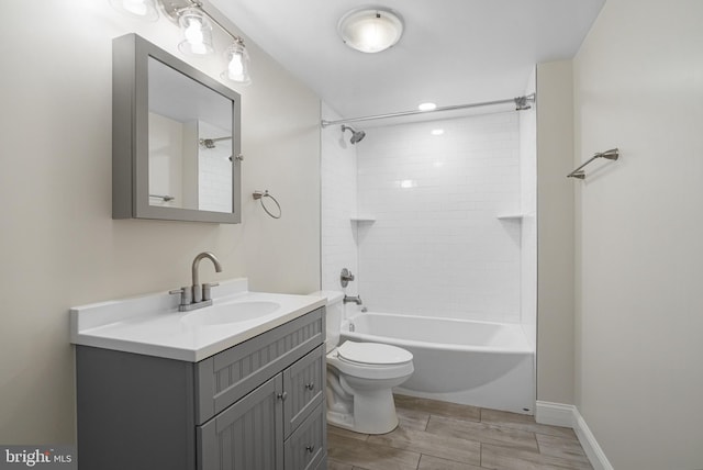 bathroom with toilet, bathing tub / shower combination, vanity, and baseboards