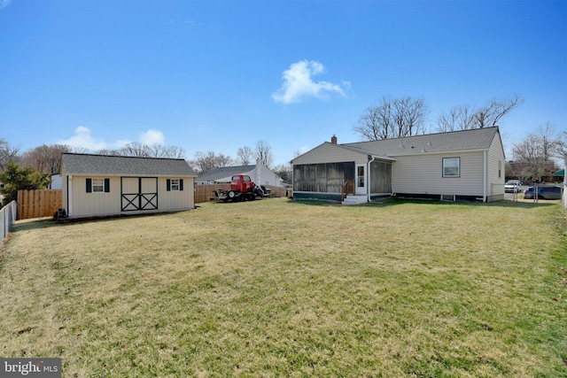 back of house with a fenced backyard, an outdoor structure, a sunroom, a lawn, and a shed