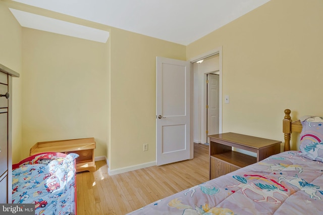 bedroom with baseboards and wood finished floors