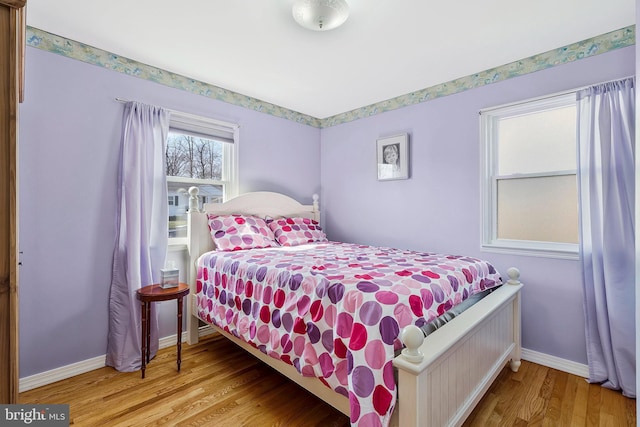 bedroom with baseboards and wood finished floors