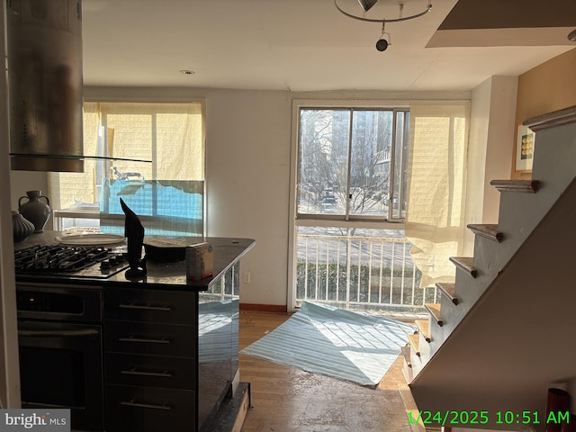 interior space with stairway, baseboards, and wood finished floors