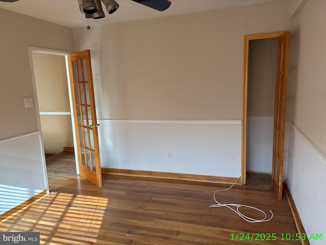 empty room with a ceiling fan, baseboards, and wood finished floors