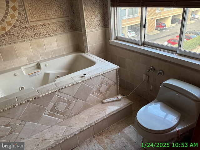 full bathroom featuring a jetted tub, toilet, and tile walls