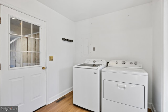 clothes washing area with visible vents, baseboards, washer and clothes dryer, electric panel, and laundry area