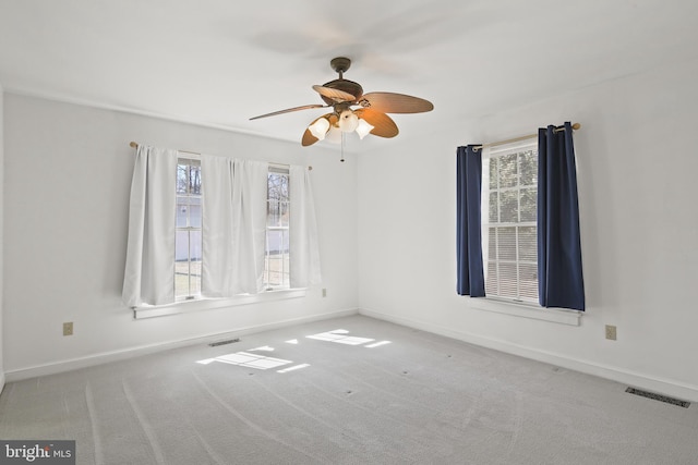 unfurnished room featuring carpet, visible vents, and baseboards