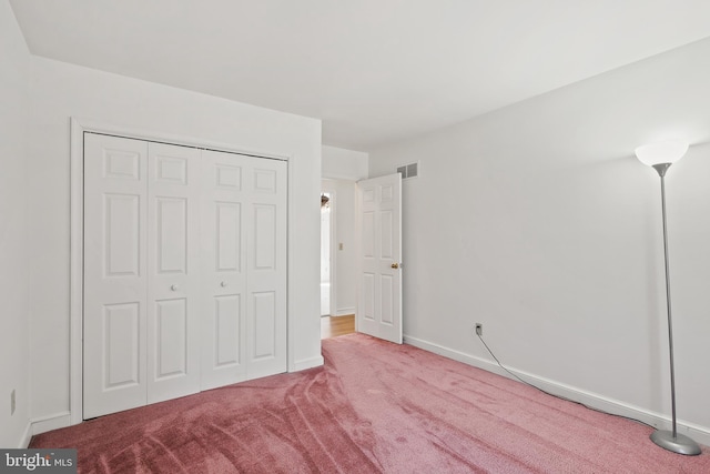 unfurnished bedroom featuring a closet, visible vents, carpet flooring, and baseboards