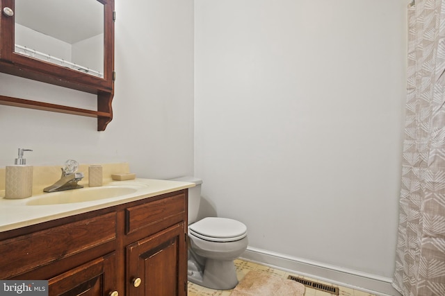 bathroom with vanity, baseboards, visible vents, tile patterned floors, and toilet