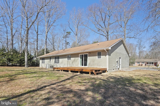 back of property with a wooden deck and a yard