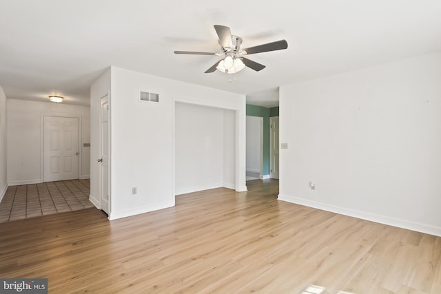 spare room featuring a ceiling fan, baseboards, visible vents, and light wood-type flooring