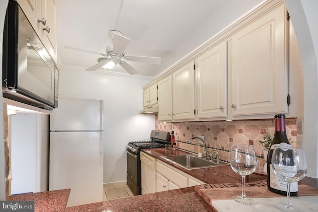 kitchen featuring a sink, range with gas stovetop, ornamental molding, backsplash, and freestanding refrigerator