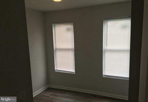 unfurnished room featuring dark wood finished floors and baseboards