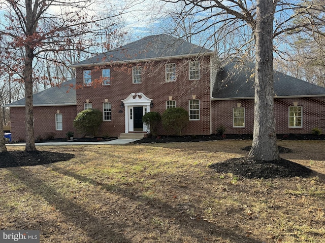 view of front facade with a front yard and brick siding