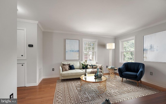 living room featuring crown molding, visible vents, baseboards, and wood finished floors