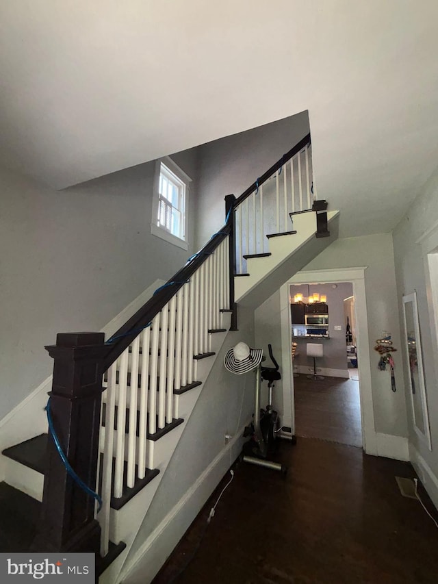 stairs featuring wood finished floors and baseboards