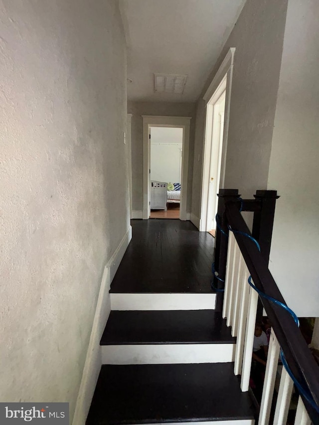 staircase with visible vents and wood finished floors