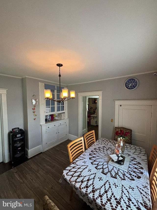 dining area with an inviting chandelier, crown molding, baseboards, and dark wood-style flooring