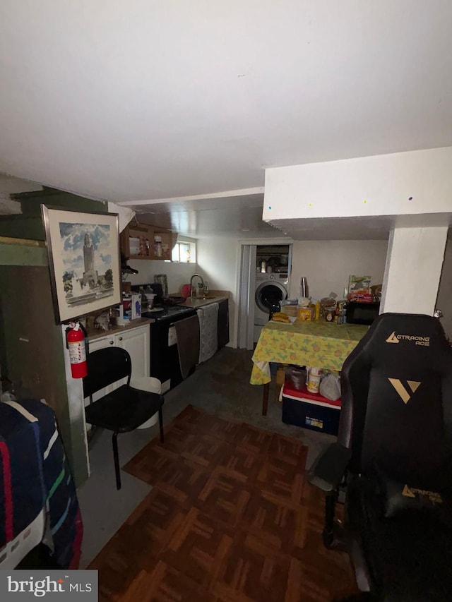 kitchen with black electric range, washer / clothes dryer, and a sink