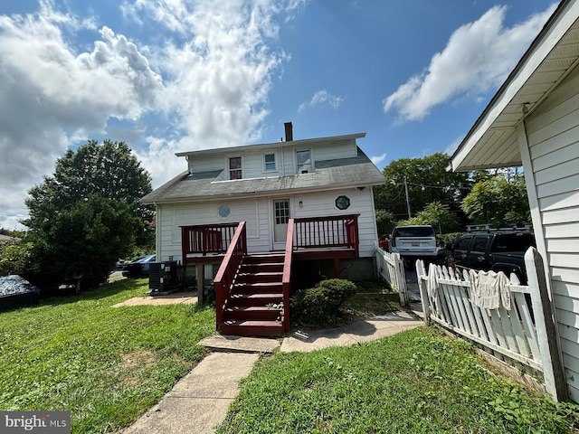 view of front of property with a front yard, fence, cooling unit, a wooden deck, and stairs