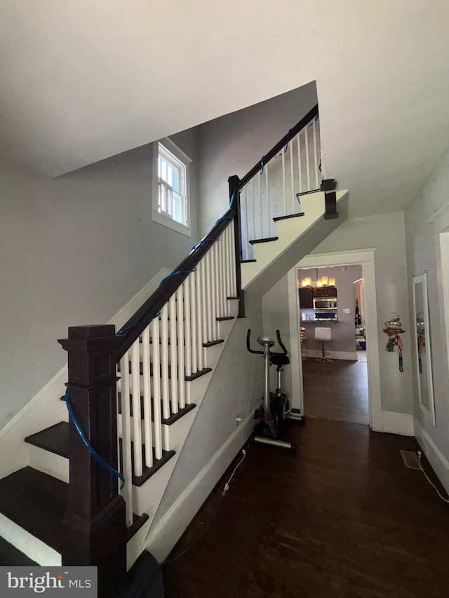 stairway featuring wood finished floors and baseboards