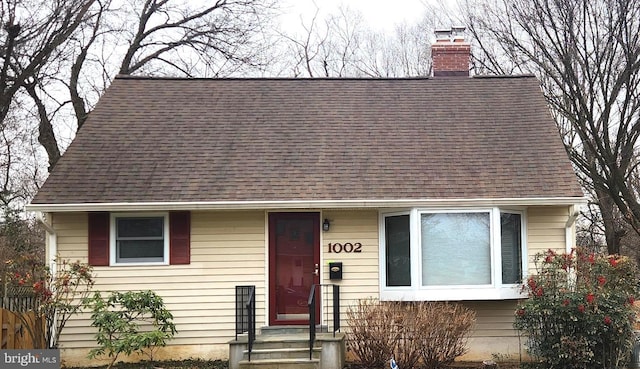 view of front of property featuring roof with shingles and a chimney