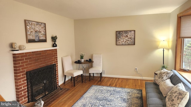 living room with a fireplace, wood finished floors, and baseboards