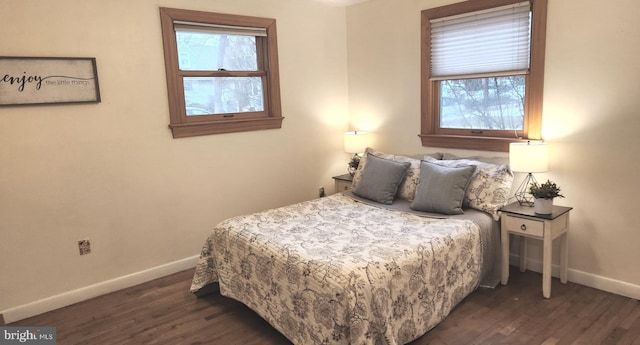 bedroom with dark wood-type flooring and baseboards