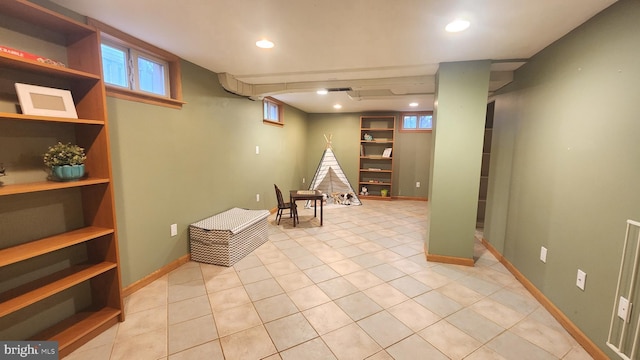 below grade area featuring light tile patterned floors, recessed lighting, and baseboards