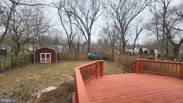 deck featuring a storage shed, an outdoor structure, and a fenced backyard