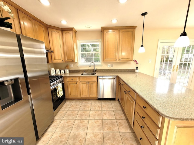 kitchen featuring recessed lighting, stainless steel appliances, a peninsula, a sink, and light stone countertops