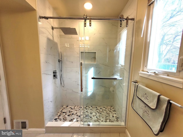 bathroom featuring visible vents and a marble finish shower