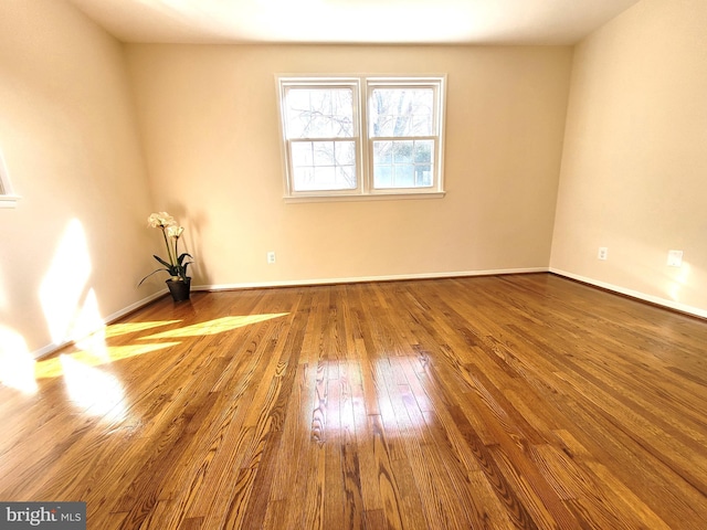 empty room featuring baseboards and hardwood / wood-style flooring