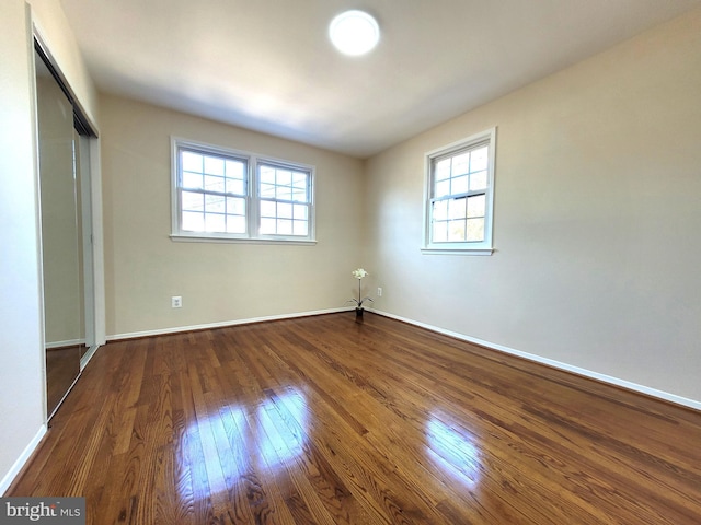 empty room with dark wood-style floors and baseboards