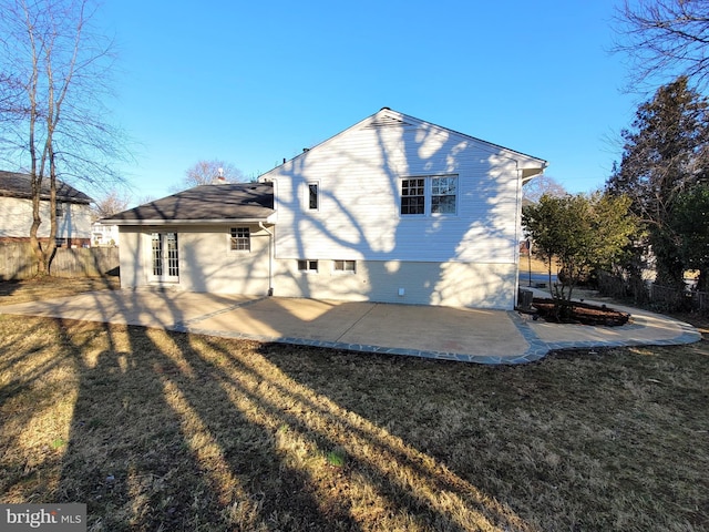 rear view of property featuring a patio area, fence, and a lawn