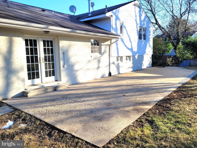 back of property with a patio area, french doors, and brick siding