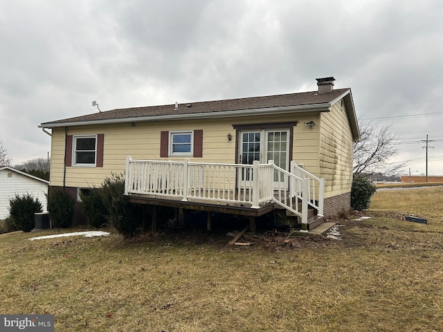 back of house featuring central AC, a lawn, a chimney, and a wooden deck