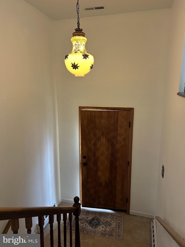 foyer entrance featuring baseboards, visible vents, baseboard heating, and tile patterned flooring