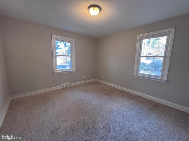 carpeted empty room with visible vents and baseboards