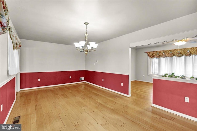 spare room featuring visible vents, a notable chandelier, and hardwood / wood-style floors