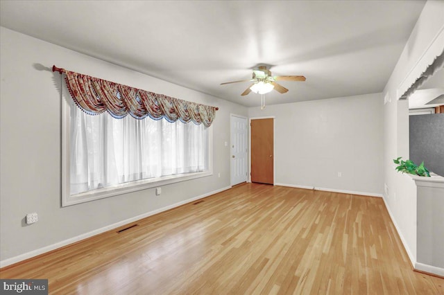 empty room with light wood-style flooring, visible vents, ceiling fan, and baseboards