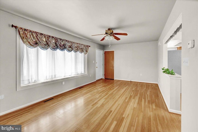 unfurnished living room featuring a ceiling fan, wood finished floors, visible vents, and baseboards